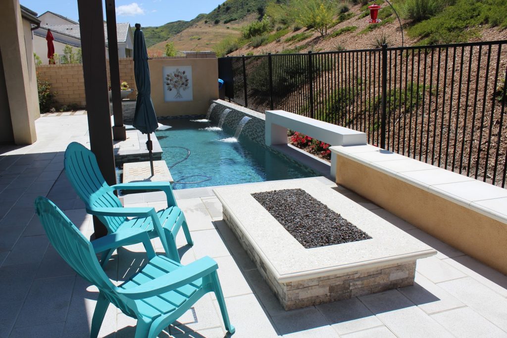 A small backyard is transformed with a contemporary pool and fire pit