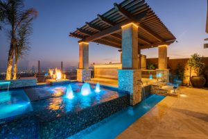 Backyard with pool with LED outdoor lighting and kitchen under pergola