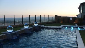 low splash orb fountains by a modern swimming pool
